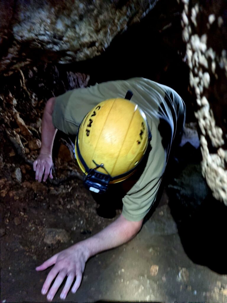 Adventure Image -  Richard crawling through a cave tunnel.