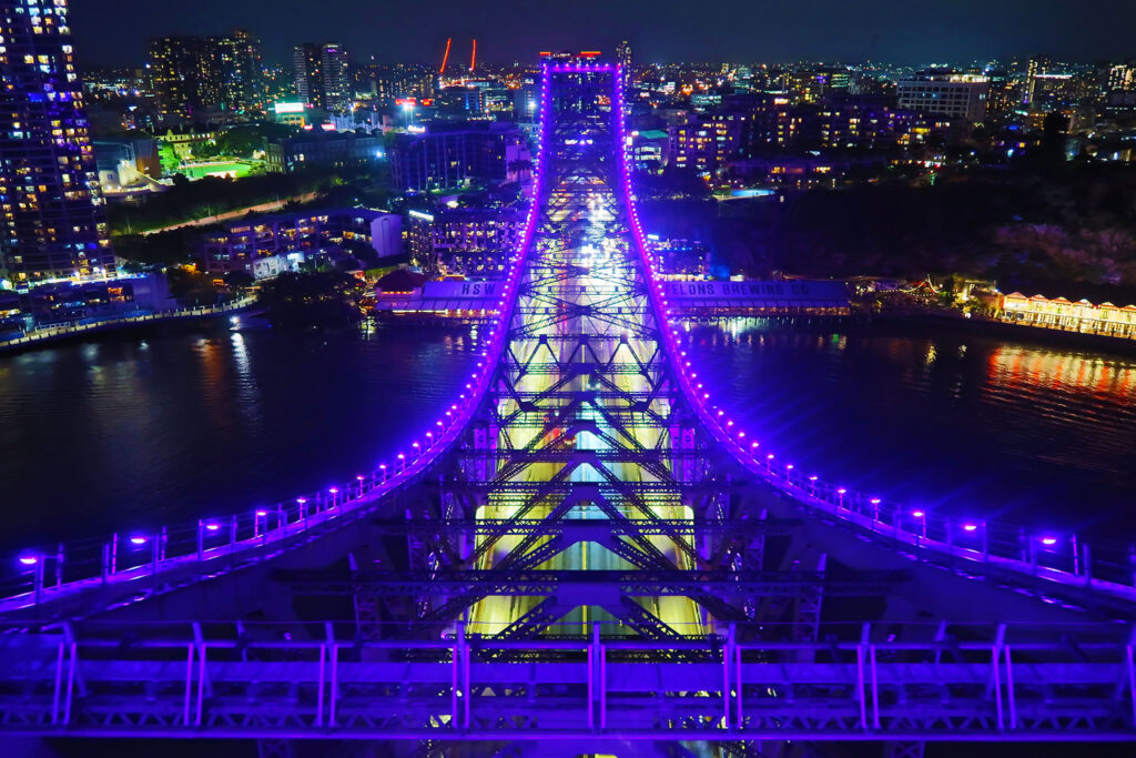 Adventure Image -  Storey bridge lit up at night. The image is taken from the highest peak of the bridge looking north.